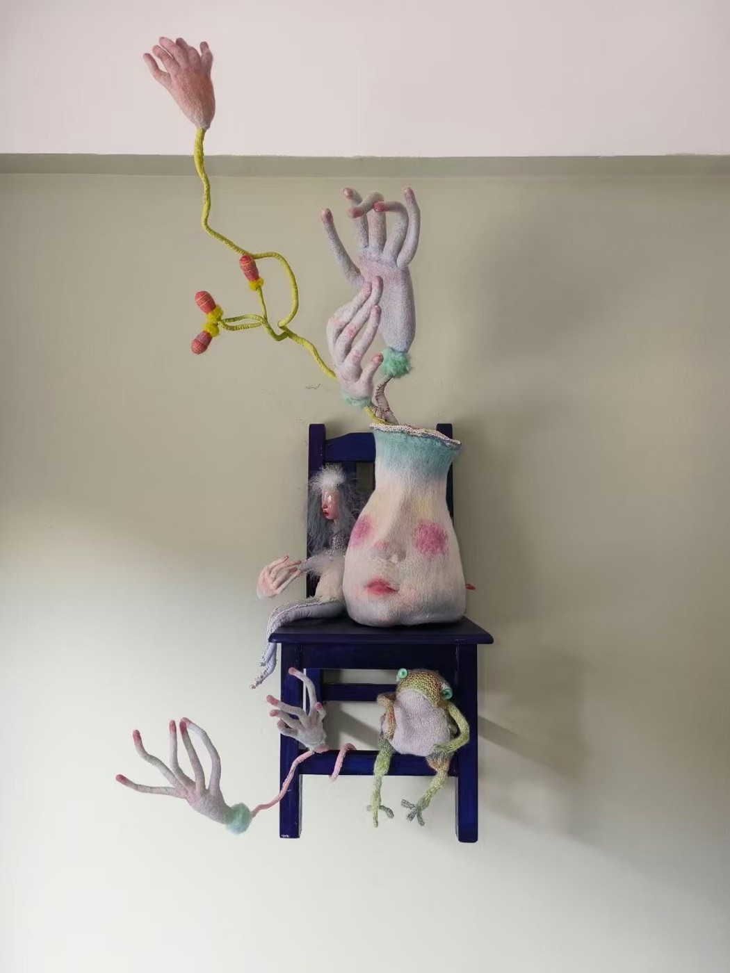 Archive mixed soft sculpture with chair, small figure, vessel face, and branching hands.