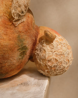 Side detail of Broken Jar's head and body, showing the creature's vessel-like form and damaged textile surface.