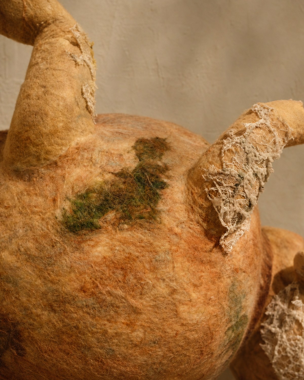 Body and leg detail of Broken Jar showing the rounded wool vessel form, stitched texture, and bent soft limbs.
