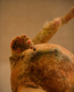 Hand detail of Broken Jar showing small wool fingers, patched textile texture, and a fragile sculptural surface.