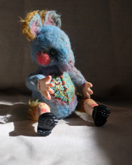 Material detail of Dream Thief showing wool fiber, embroidery, beads, and textile accents.