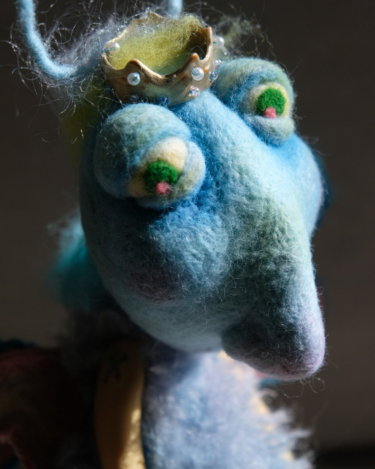 Close detail of King Aster's head, crown, wool texture, and heart-shaped antennae.
