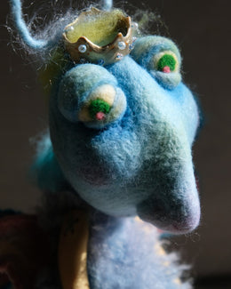 Close detail of King Aster's head, crown, wool texture, and heart-shaped antennae.