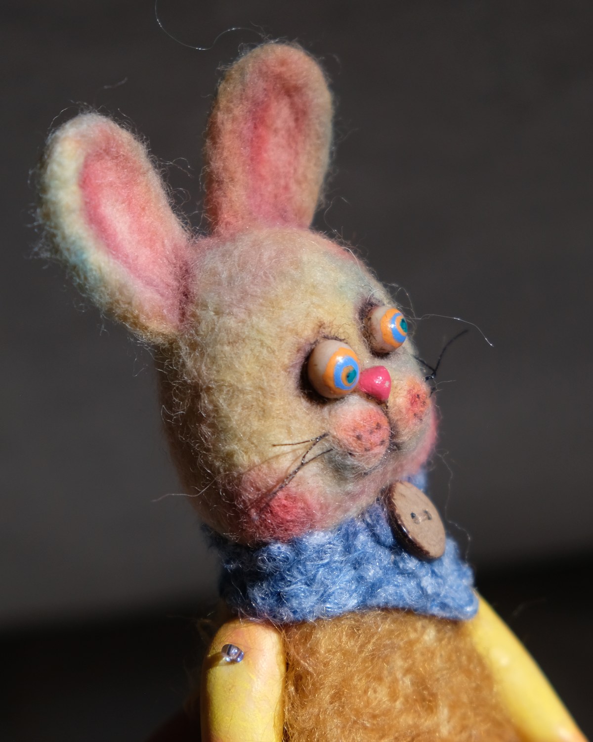 Close detail of Tick Tock's rabbit face, long ears, button collar, whiskers, and hand-felted wool texture.