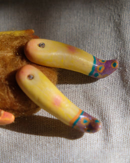 Leg detail of Tick Tock showing yellow sculpted legs, tiny screws, and painted purple shoes.