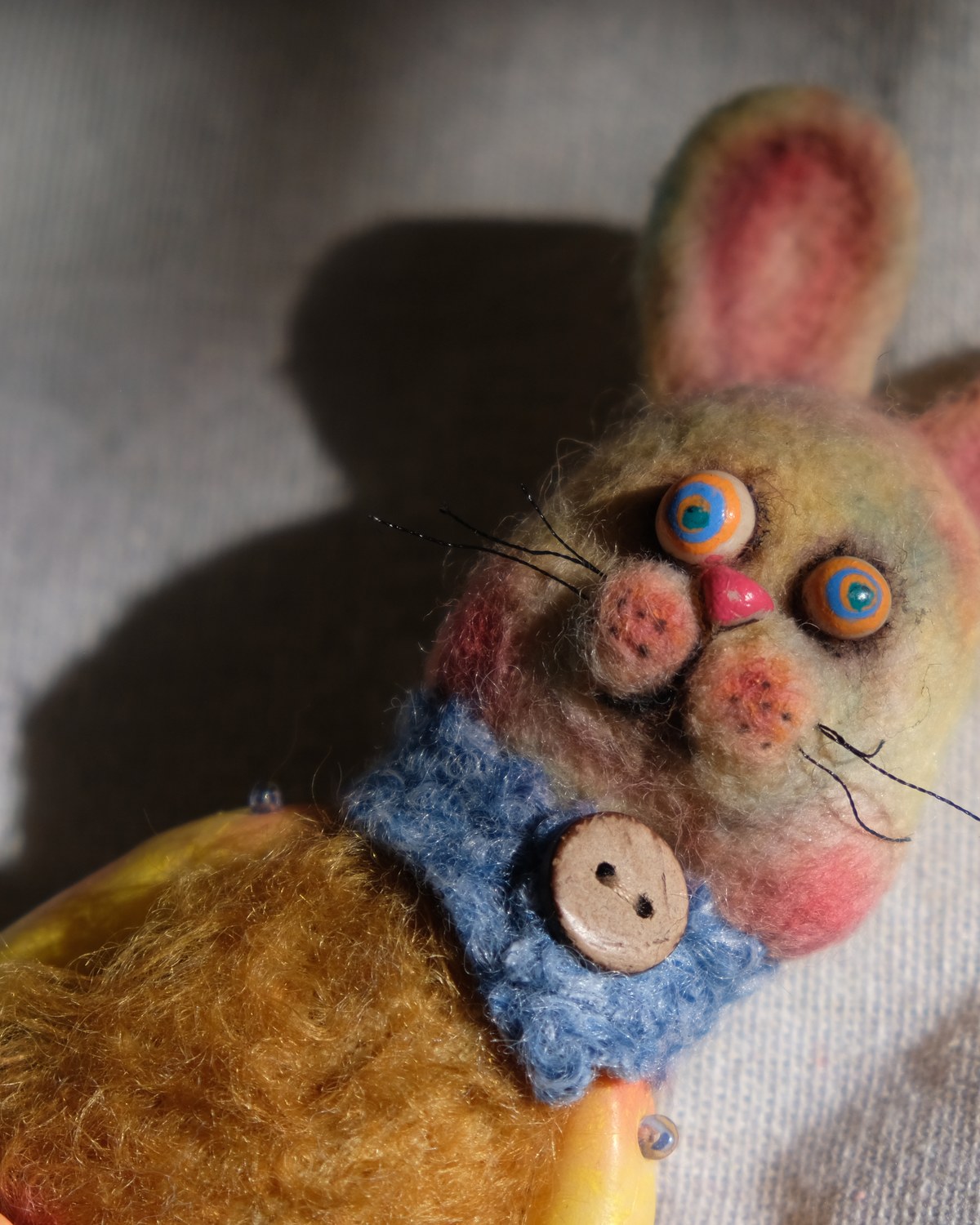 Half-body detail of Tick Tock with its anxious rabbit face, button collar, wool body, and dramatic shadow.