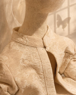 Clothing detail of Zhuang Sheng showing textured cotton textile, soft wool surface, collar, and small handmade fastenings.